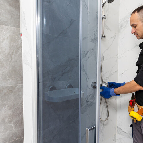 Plumber installing a shower stall