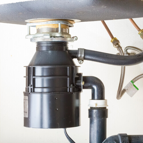 Under the sink garbage disposal unit.