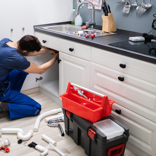 Plumber In Overall Fixing Sink Pipe